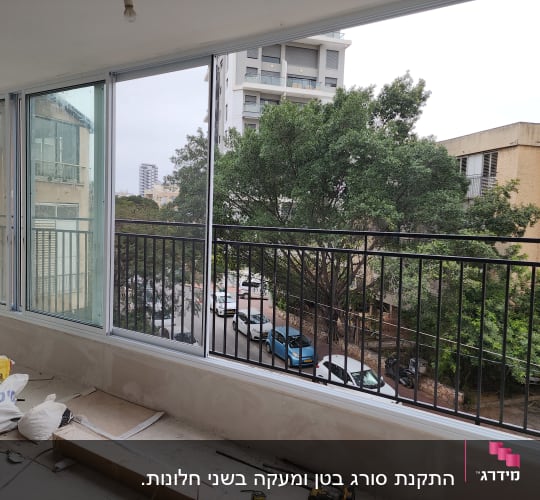 מסגרת חלונות זכוכית עם נוף לעיר ועצים